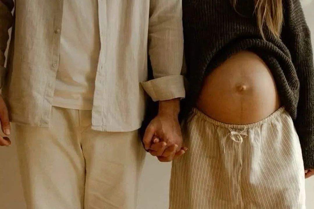Couple holding hands, expecting a baby